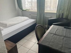 Habitación con cama, silla y mesa. en Hotel & Restaurant Main Taunus, en Hochheim am Main