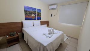 a small room with a bed with white sheets at Arena Carneiros Hotel by AFT in Tamandaré