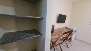 a room with two chairs and a desk with a television at Arena Carneiros Hotel by AFT in Tamandaré