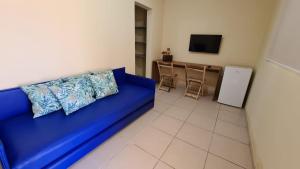 a blue couch with pillows in a living room at Arena Carneiros Hotel by AFT in Tamandaré