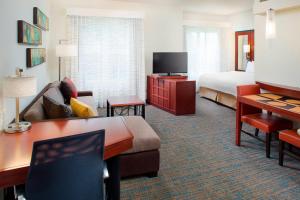 a hotel room with a bed and a couch and a desk at Residence Inn by Marriott Roanoke Airport in Roanoke
