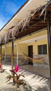 a house with a hammock in front of it at Arena Carneiros Hotel by AFT in Tamandaré