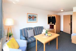 ein Wohnzimmer mit einem blauen Sofa und einem Tisch in der Unterkunft Ferienzimmeranlage Deutsches Haus Deutsches Haus App 39 in Wustrow