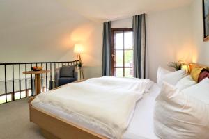 1 dormitorio con 1 cama con sábanas blancas y ventana en Ferienzimmeranlage Deutsches Haus Deutsches Haus App 39 en Wustrow