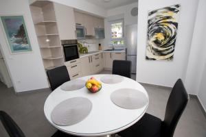 a kitchen with a white table with a bowl of fruit on it at Luxury Apartment Luka in Promajna