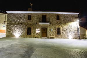 - un bâtiment en pierre avec une porte en bois la nuit dans l'établissement El Pelaor, à Benquerencia