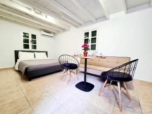 una camera con letto, tavolo e sedie di Piccolo Modern Suites Old Town a Città di Rodi