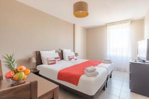 ein Hotelzimmer mit einem Bett und einem Tisch mit einer Obstschale in der Unterkunft Appart'City Confort Toulouse Aéroport Cornebarrieu in Cornebarrieu