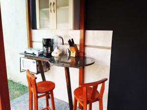 ブルメナウにあるEspaço aconchegante Blumenauのテーブルの横に椅子2脚付きカウンター