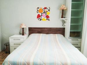 a bedroom with a bed and two night stands and two lamps at Espaço aconchegante Blumenau in Blumenau