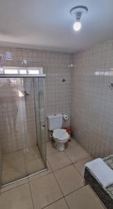 a bathroom with a toilet and a glass shower at Arena Carneiros Hotel by AFT in Tamandaré
