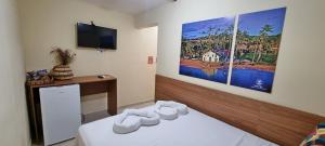 a hotel room with a bed with a tv on the wall at Arena Carneiros Hotel by AFT in Tamandaré