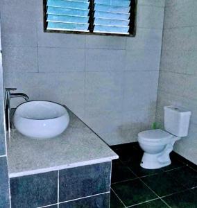 a bathroom with a toilet and a sink and a window at ISLA tress Bonita Wellness Escape Island in San Vicente