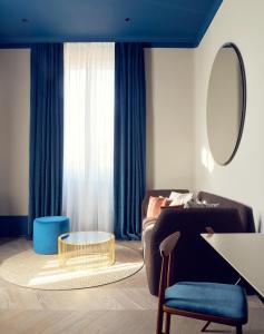 a living room with a couch and a table and a mirror at Palazzo Velabro, a Member of Design Hotels in Rome