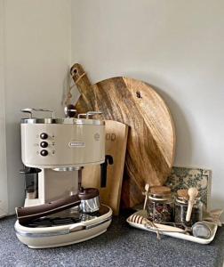 een koffiezetapparaat op een aanrecht naast een houten kom bij Brocante Holiday Home aan de bosrand! in Ermelo
