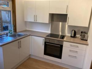 a kitchen with white cabinets and a sink at The Panthouse Lodge in Felton