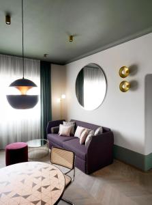 Palazzo Velabro, a Member of Design Hotels في روما: غرفة معيشة مع أريكة وطاولة
