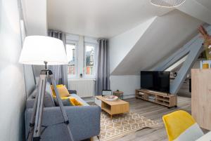 sala de estar con sofá azul y TV en Le 38-GregIMMO-Appart'Hôtel en Belfort