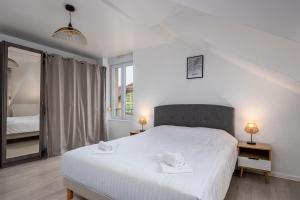 Un dormitorio con una gran cama blanca y una ventana en Le 38-GregIMMO-Appart'Hôtel en Belfort
