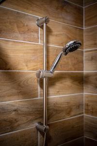 un cabezal de ducha en una pared de madera en Le 38-GregIMMO-Appart'Hôtel en Belfort