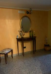 a dressing table with a mirror and a stool at B & B Il Giardino in Noto