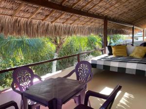 a porch with a bed and chairs and a table at Pousada MYM JERI ate 3x in Jericoacoara