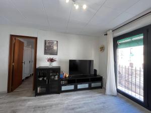 a living room with a flat screen tv and a window at Apartamento Sedassos Circo Romano in Tarragona