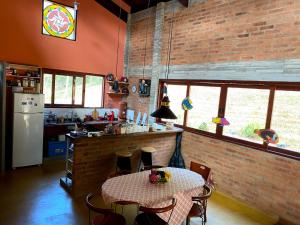 a kitchen with a table and a brick wall at Casa Cacau Boutique B&B - Sítio Salamandra, Vale do Matutu in Aiuruoca