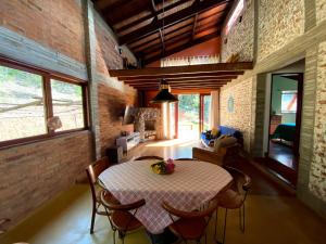 a kitchen and dining room with a table and chairs at Casa Cacau Boutique B&B - Sítio Salamandra, Vale do Matutu in Aiuruoca
