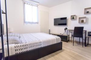 a bedroom with a bed and a desk and a television at Le Brivet ☆ Hypercentre ☆ Parking ☆ Terrasse in Pontchâteau