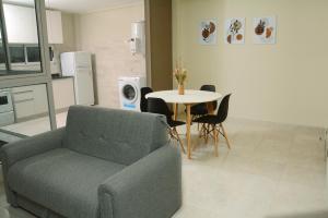 uma sala de estar com um sofá e uma mesa com cadeiras em Villa Apart Center em Villa Constitución
