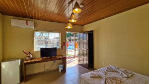 a bedroom with a bed and a desk with a computer at Arena Carneiros Hotel by AFT in Tamandaré