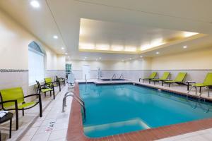 einen Pool mit grünen Stühlen und einem Pool in der Unterkunft SpringHill Suites by Marriott Williamsburg in Williamsburg
