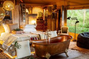 una camera con letto e vasca da bagno accanto a una sedia di Areias do Seixo Hotel a Santa Cruz