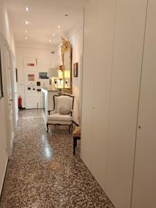 ein Flur mit einem Stuhl und einem Spiegel in der Unterkunft DORA AUREA in Levanto