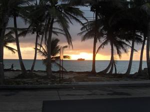 a sunset on the beach with palm trees at Villa Sunny Days in San Andrés