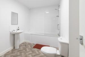 a white bathroom with a toilet and a sink at Yarm Lane Apartments - Stockton Town Centre in Stockton-on-Tees