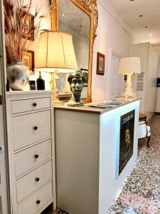 una camera con cassettiera, lampada e specchio di DORA AUREA a Levanto