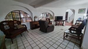 Hermosa Casa Silemi en Puerto Vallarta في Las Juntas: غرفة معيشة مع عدة كراسي وتلفزيون