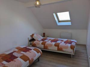 Duas camas num quarto branco com uma janela em l'Opale Break em Calais