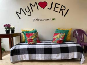 um quarto com uma cama com uma placa na parede em Pousada MYM JERI ate 3x em Jericoacoara