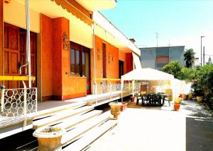 een gebouw met een patio met een tafel en een parasol bij Villetta Hydro 3 in Bagnolo del Salento