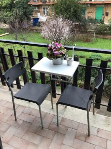a white table and two chairs and a table with flowers at casa Marilena in Tivoli
