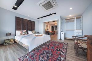 a bedroom with a large bed and a living room at Central Bangkok, 5 stars river view & characteristic decor in Bangkok
