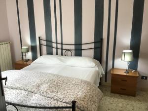 ein Schlafzimmer mit einem Bett und zwei Tischen mit Lampen in der Unterkunft casa Marilena in Tivoli