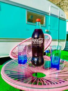 a bottle of cocacola on a pink plate with two glasses at Tropical Dreams Motril in Los Tablones