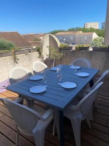 niebieski stół z białymi krzesłami na tarasie w obiekcie SAMARIA VILLAGE Magnifique appartement 8 personnes Rochelongue Cap d'Agde w Cap d'Agde