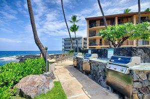 a resort with a grill and a beach at Kona Makai 3102 in Kailua-Kona