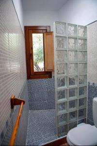 łazienka z toaletą i przeszkloną ścianą w obiekcie El Rincón de los Albaricoques w mieście Níjar
