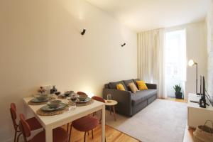 een woonkamer met een tafel en een bank bij Cativo Design Apartment in Porto